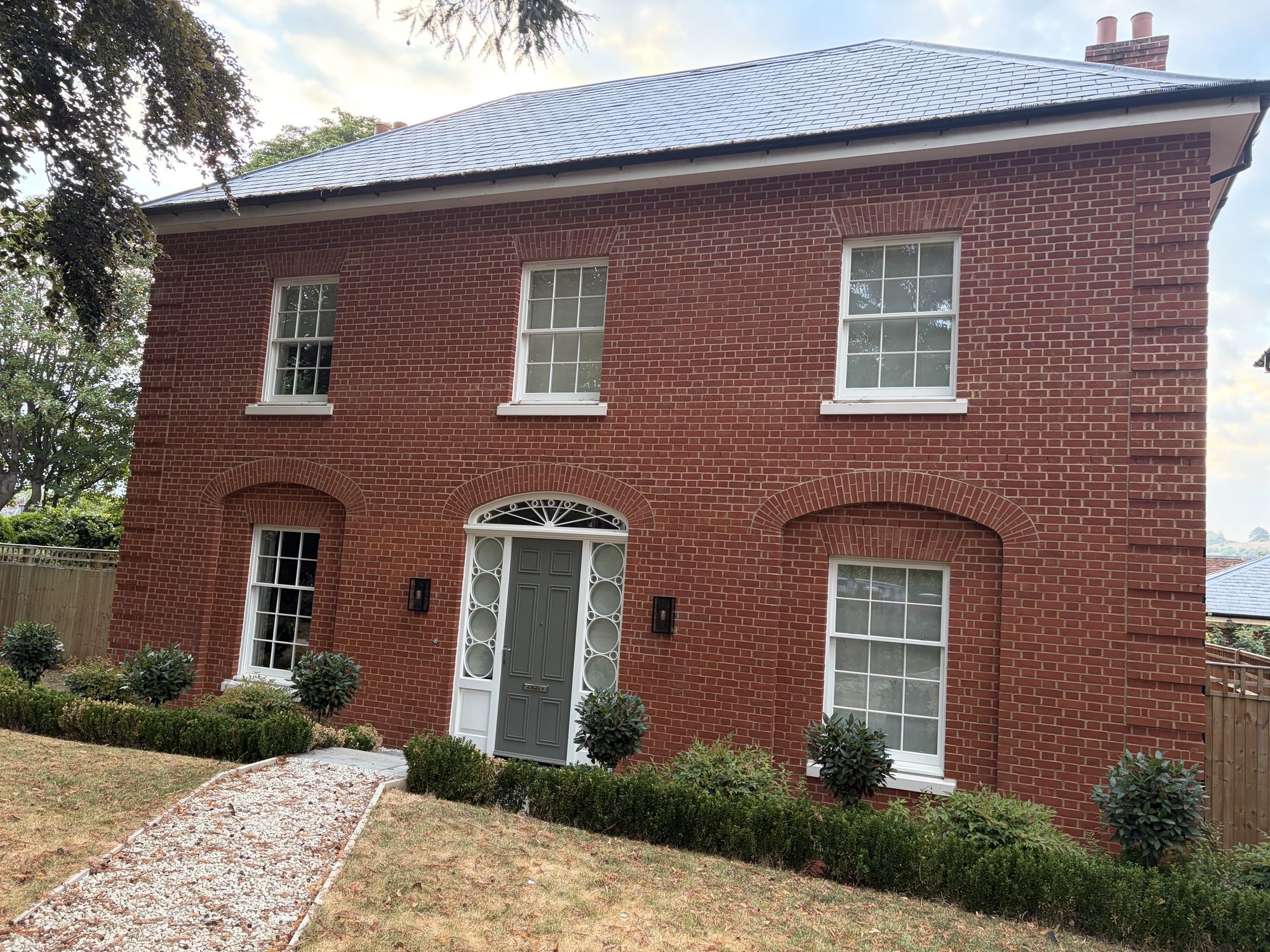 Red-brick house with arched door and window surrounds at the St Cross Road development in Winchester